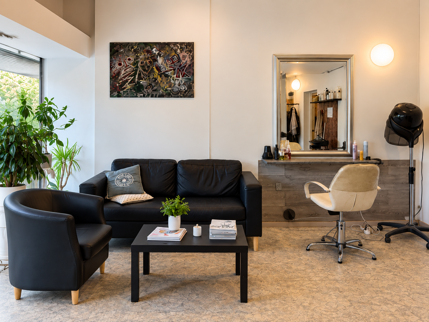 Salon Sharons venteområde med sort lædersofa